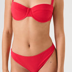 Bikini sostenible Bimba Berry. Top balconette con aro y braguita de corte clásico. Tejido reciclado ECONYL® en rojo cereza con textura atoallada. Diseño elegante y favorecedor hecho en España de forma ética.