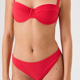 Bikini sostenible Bimba Berry. Top balconette con aro y braguita de corte clásico. Tejido reciclado ECONYL® en rojo cereza con textura atoallada. Diseño elegante y favorecedor hecho en España de forma ética.