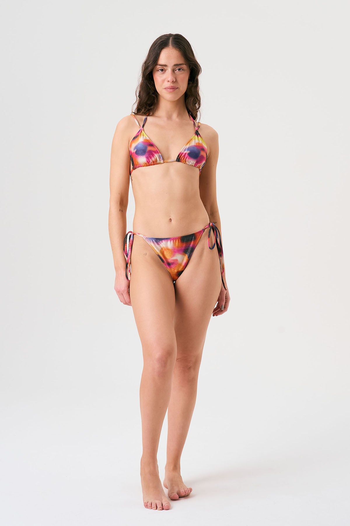 Bikini sostenible Lise Gara Calei. Top triangular multiposición y braga normal con lazada. Tejido ECOWAVE® con estampado tie-dye acuarelado y acabado lúrex. Hecho en España con producción ética.