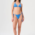 Bikini sostenible Lise Positano. Top triangular multiposición y braga tanga con lazada. Tejido reciclado ECONYL® en azul cristalino con textura atoallada. Hecho a mano en España.