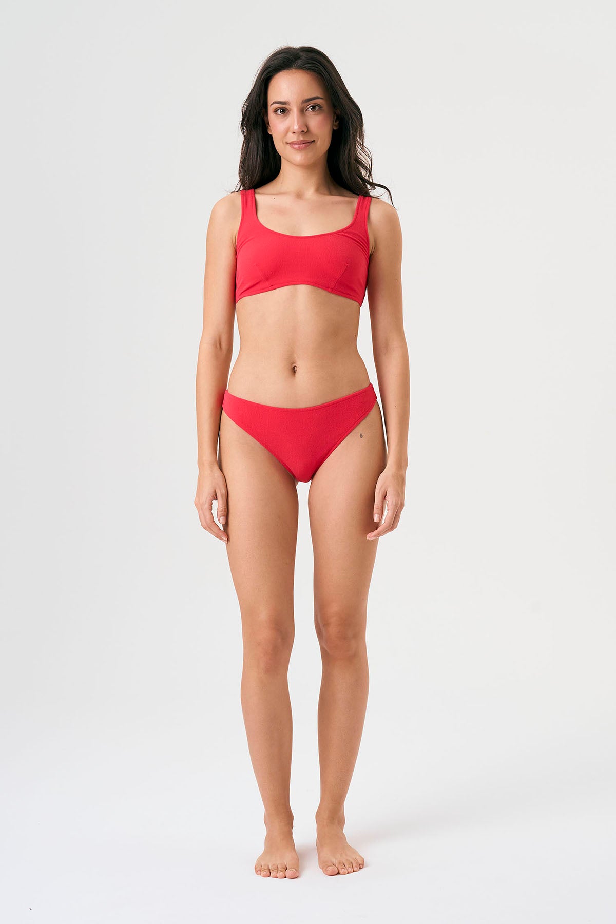 Bikini sostenible Mani Bimba Berry de CIRCU. Top deportivo con tirantes anchos para sujeción y braguita de corte clásico comfort. Tejido reciclado ECONYL® en color rojo cereza con textura atoallada. Hecho artesanalmente en España.