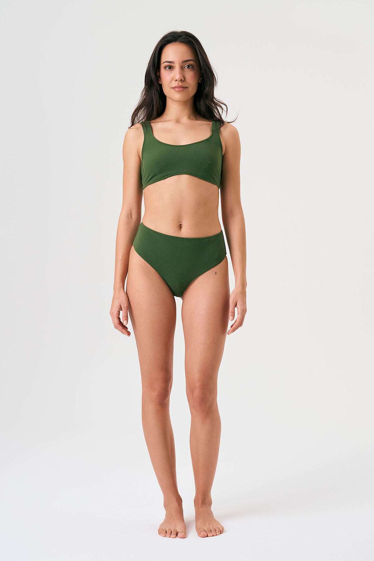 Bikini sostenible deportivo Mani Bimba Palm High. Top con tirantes anchos y gran sujeción. Braguita de tiro alto que estiliza. Tejido reciclado ECONYL® en verde mediterráneo con textura atoallada. Hecho en España.