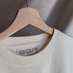Camiseta oversize unisex en color blanco beige, confeccionada en 100% algodón orgánico, con impresión digital exclusiva en la parte delantera. Moda streetwear sostenible