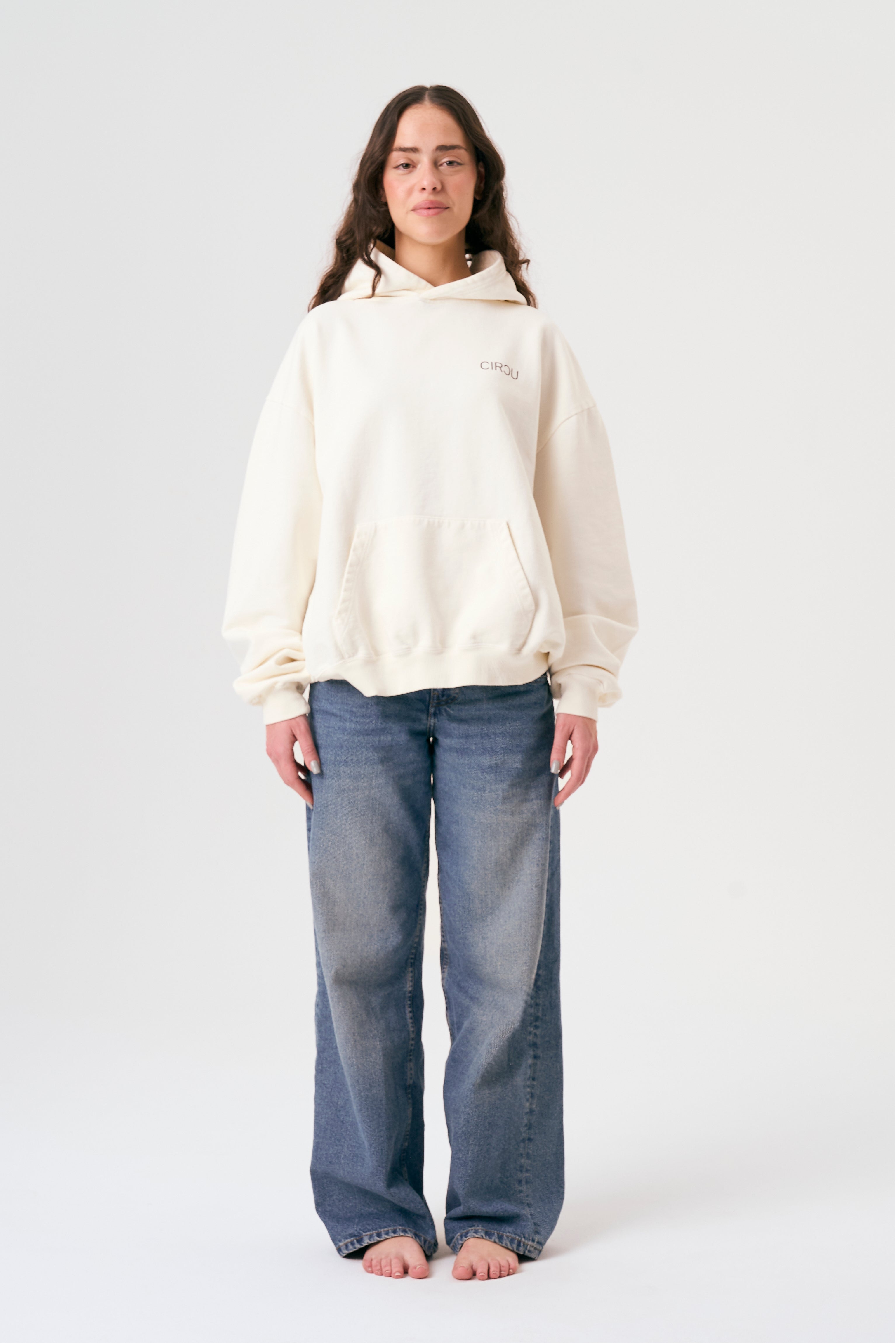 Sudadera oversize unisex con capucha en color blanco beige, confeccionada en algodón orgánico 100% con acabado French Terry. Su diseño exclusivo, con impresión digital en la parte delantera y trasera, combina comodidad, estilo y sostenibilidad. Una hoodie streetwear perfecta para un look casual y versátil.