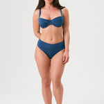 Bikini sostenible Bimba Aqua High de CIRCU. Top balconette con aro y braga alta que estiliza. Tejido ECONYL® en azul marino satinado, elegante y atemporal. Hecho a mano en España de forma ética.