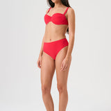 Bikini sostenible Bimba Berry High de CIRCU. Top balconette con aro, tirantes regulables y lazada trasera. Braga alta en color rojo cereza con textura atoallada. Tejido reciclado ECONYL®. Hecho éticamente en España.