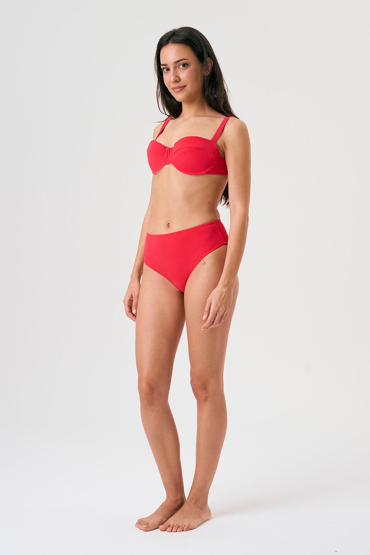 Bikini sostenible Bimba Berry High de CIRCU. Top balconette con aro, tirantes regulables y lazada trasera. Braga alta en color rojo cereza con textura atoallada. Tejido reciclado ECONYL®. Hecho éticamente en España.