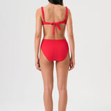 Bikini sostenible Bimba Berry High de CIRCU. Top balconette con aro, tirantes regulables y lazada trasera. Braga alta en color rojo cereza con textura atoallada. Tejido reciclado ECONYL®. Hecho éticamente en España.