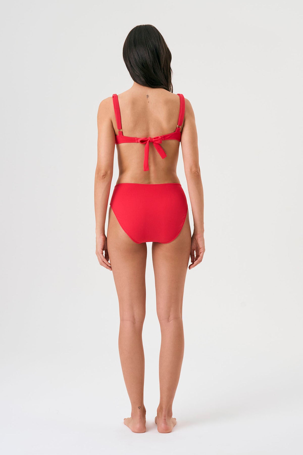 Bikini sostenible Bimba Berry High de CIRCU. Top balconette con aro, tirantes regulables y lazada trasera. Braga alta en color rojo cereza con textura atoallada. Tejido reciclado ECONYL®. Hecho éticamente en España.
