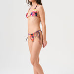 Bikini sostenible Lise Gara Calei. Top triangular multiposición y braga normal con lazada. Tejido ECOWAVE® con estampado tie-dye acuarelado y acabado lúrex. Hecho en España con producción ética.