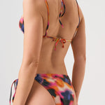 Bikini sostenible Lise Gara Calei. Top triangular multiposición y braga normal con lazada. Tejido ECOWAVE® con estampado tie-dye acuarelado y acabado lúrex. Hecho en España con producción ética.