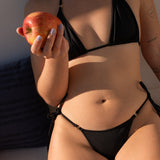 Detalle torso bikini Lise Moon negro con manzana luz atardecer - CIRCU