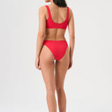 Bikini sostenible Mani Bimba Berry de CIRCU. Top deportivo con tirantes anchos para sujeción y braguita de corte clásico comfort. Tejido reciclado ECONYL® en color rojo cereza con textura atoallada. Hecho artesanalmente en España.