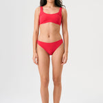 Bikini sostenible Mani Bimba Berry de CIRCU. Top deportivo con tirantes anchos para sujeción y braguita de corte clásico comfort. Tejido reciclado ECONYL® en color rojo cereza con textura atoallada. Hecho artesanalmente en España.