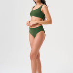 Bikini sostenible deportivo Mani Bimba Palm High. Top con tirantes anchos y gran sujeción. Braguita de tiro alto que estiliza. Tejido reciclado ECONYL® en verde mediterráneo con textura atoallada. Hecho en España.