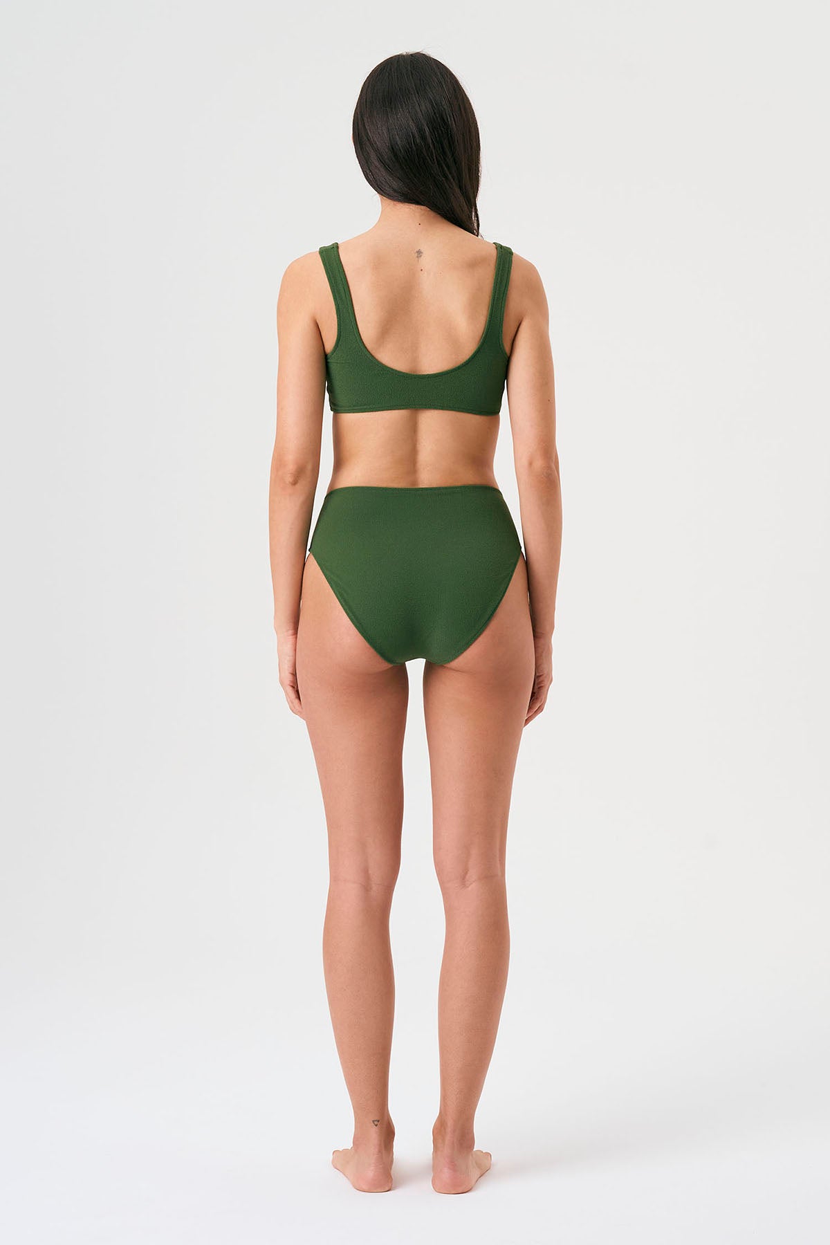 Bikini sostenible deportivo Mani Bimba Palm High. Top con tirantes anchos y gran sujeción. Braguita de tiro alto que estiliza. Tejido reciclado ECONYL® en verde mediterráneo con textura atoallada. Hecho en España.