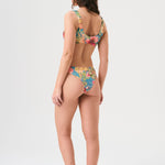 Bikini sostenible deportivo Mani Aloa. Tejido reciclado ECOWAVE® y estampado ZEROWATER. Top deportivo con tirantes anchos y braga brasileña. Print floral en textura piqué con acabado lúrex. Hecho éticamente en España.