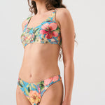 Bikini sostenible deportivo Mani Aloa. Tejido reciclado ECOWAVE® y estampado ZEROWATER. Top deportivo con tirantes anchos y braga brasileña. Print floral en textura piqué con acabado lúrex. Hecho éticamente en España.