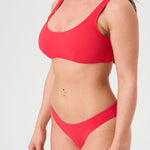 Bikini sostenible deportivo Mani Berry. Top con tirantes anchos de gran sujeción y braguita brasileña. Tejido reciclado ECONYL® en rojo cereza con textura atoallada. Hecho en España de forma ética y artesanal.