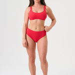 Bikini sostenible deportivo Mani Bimba Berry High. Top deportivo con tirantes anchos y braguita alta. Tejido reciclado ECONYL®. Color rojo cereza con textura atoallada. Hecho en España de forma ética. Ideal para máximo confort y sujeción.