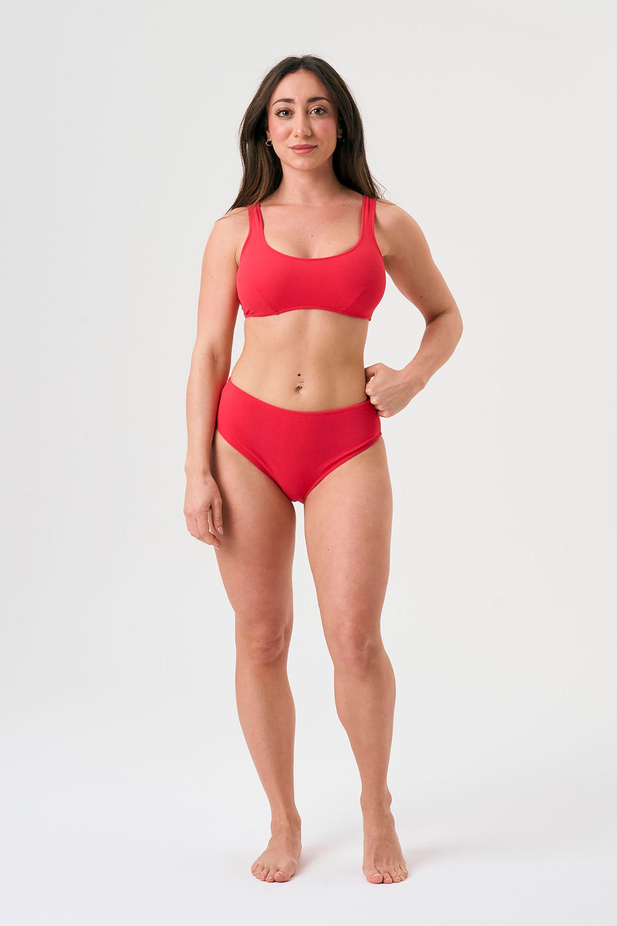 Bikini sostenible deportivo Mani Bimba Berry High. Top deportivo con tirantes anchos y braguita alta. Tejido reciclado ECONYL®. Color rojo cereza con textura atoallada. Hecho en España de forma ética. Ideal para máximo confort y sujeción.