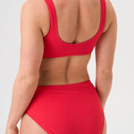 Bikini sostenible deportivo Mani Bimba Berry High. Top deportivo con tirantes anchos y braguita alta. Tejido reciclado ECONYL®. Color rojo cereza con textura atoallada. Hecho en España de forma ética. Ideal para máximo confort y sujeción.