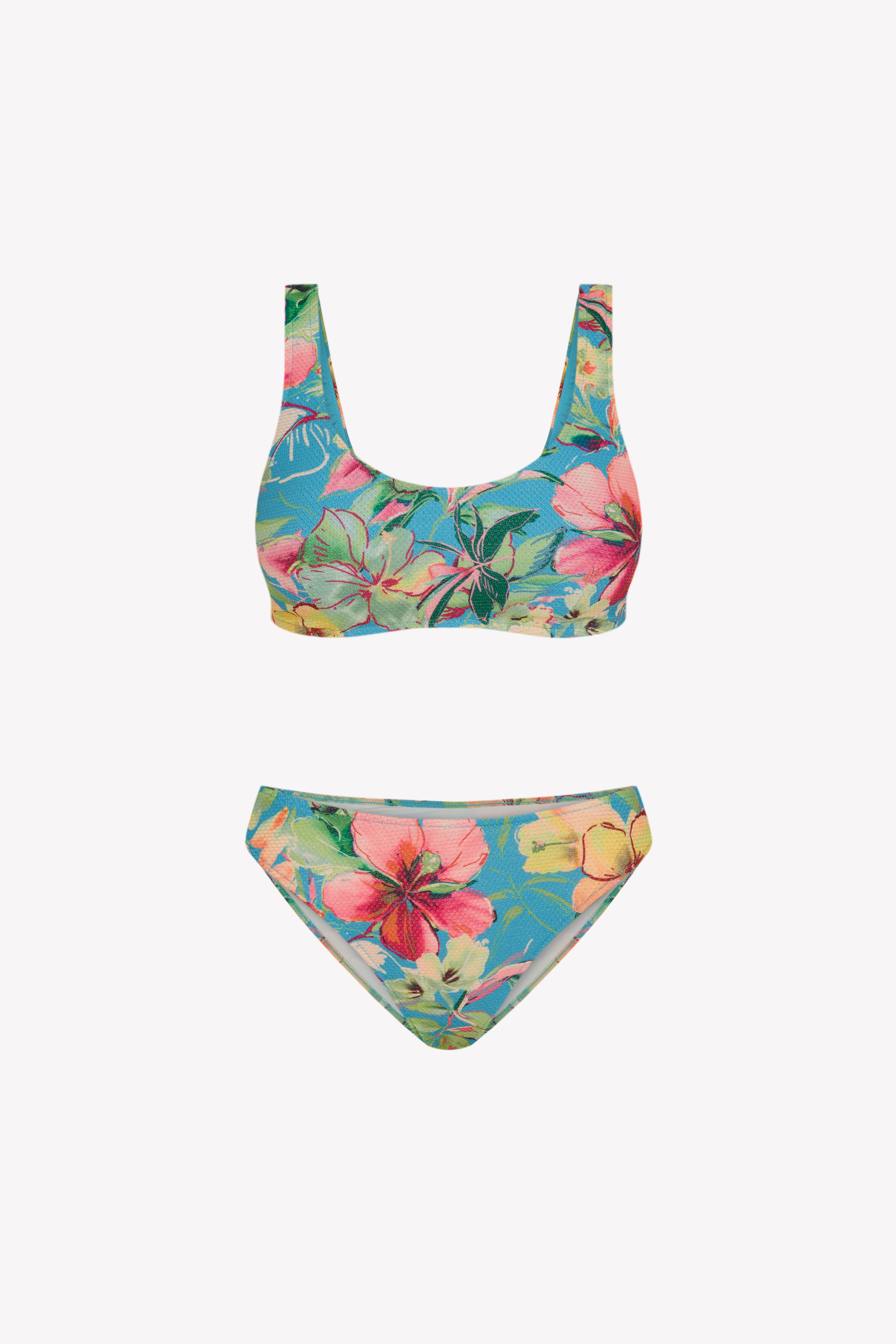 Bikini sostenible deportivo Mani Bimba Aloa. Top con tirantes anchos y sujeción óptima. Braguita de cobertura normal. Tejido reciclado ECOWAVE® con estampado floral en textura piqué y acabado lúrex. Hecho en España.
