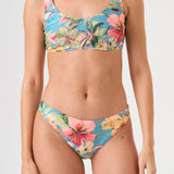 Bikini sostenible deportivo Mani Bimba Aloa. Top con tirantes anchos y sujeción óptima. Braguita de cobertura normal. Tejido reciclado ECOWAVE® con estampado floral en textura piqué y acabado lúrex. Hecho en España.