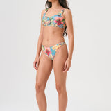Bikini sostenible deportivo Mani Bimba Aloa. Top con tirantes anchos y sujeción óptima. Braguita de cobertura normal. Tejido reciclado ECOWAVE® con estampado floral en textura piqué y acabado lúrex. Hecho en España.