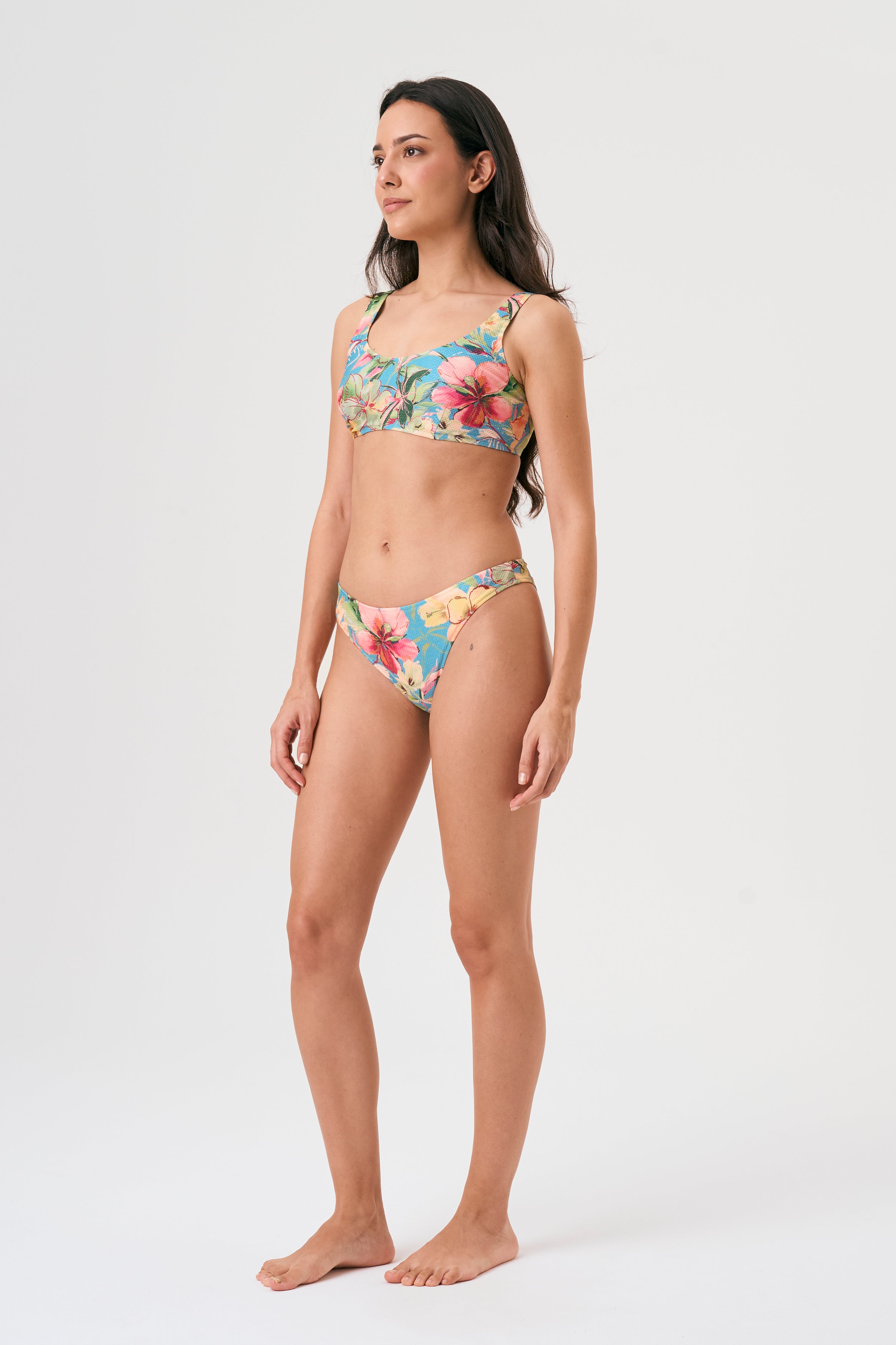 Bikini sostenible deportivo Mani Bimba Aloa. Top con tirantes anchos y sujeción óptima. Braguita de cobertura normal. Tejido reciclado ECOWAVE® con estampado floral en textura piqué y acabado lúrex. Hecho en España.