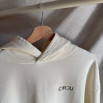 Sudadera oversize unisex con capucha en color blanco beige, confeccionada en algodón orgánico 100% con acabado French Terry. Su diseño exclusivo, con impresión digital en la parte delantera y trasera, combina comodidad, estilo y sostenibilidad. Una hoodie streetwear perfecta para un look casual y versátil.